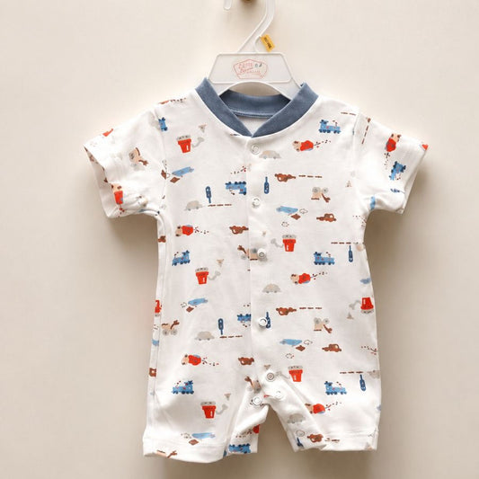 A baby short-sleeve romper hanging on a white plastic hanger against a plain beige wall. The romper is white with a blue collar and an all-over print of small red, blue, and brown vehicles and figures.