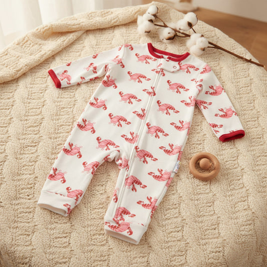 Three baby long-sleeve footless one-piece sleepers shown side by side on a white background: a white sleeper with pink flamingo print, a red sleeper with blue trim and a blue octopus graphic, and a blue sleeper with a subtle blue pattern.